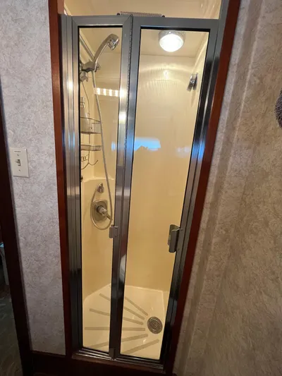 Oasis Yacht Photos Pics Shower area in 1990 Hatteras Motor Yacht with glass door and chrome fixtures.