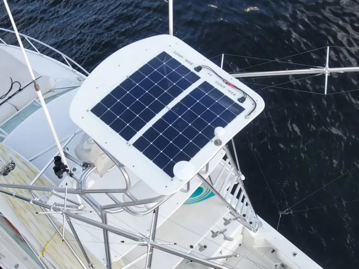 Yacht Photos Pics Solar panel on 2001 Cabo 35 Express boat, mounted on metal frame, over water.