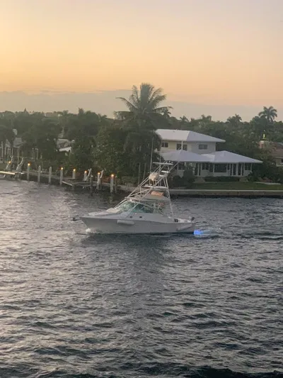  Yacht Photos Pics 2001 Cabo 35 Express boat cruising near waterfront homes at sunset.