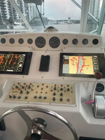  Yacht Photos Pics Control panel of a 2001 Cabo 35 Express boat with navigation screens and gauges.