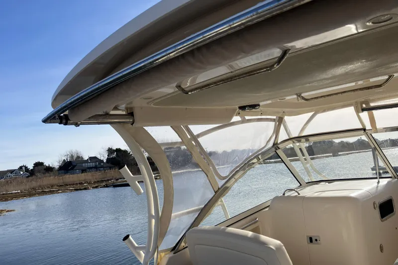 Yacht Photos Pics 2019 Grady-White Freedom 307 boat interior with clear canopy, overlooking serene waterway.