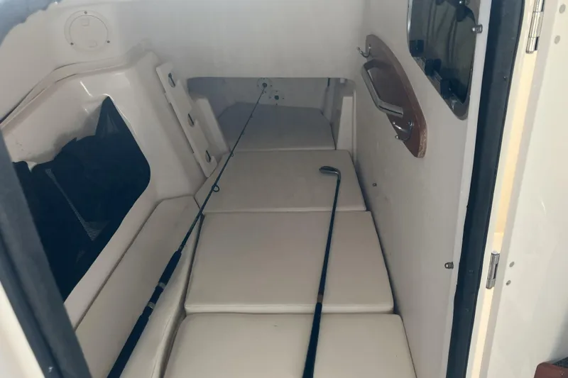  Yacht Photos Pics 2019 Grady-White Freedom 307 cabin interior with fishing rod and cushioned seating.