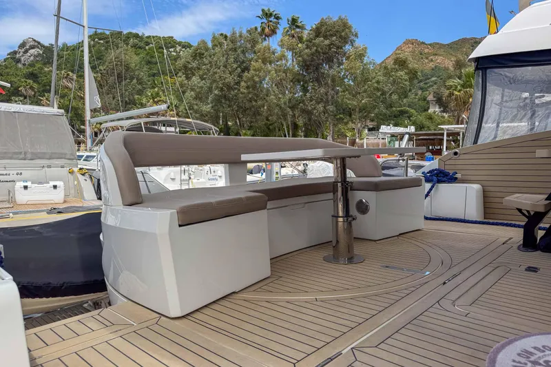 Sea Star Yacht Photos Pics 2023 Galeon 500 Fly yacht deck with seating area, surrounded by lush greenery and boats.