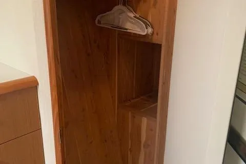  Yacht Photos Pics Wooden closet interior with hangers, inside a 2002 Viking 55 Convertible yacht.