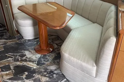  Yacht Photos Pics 2002 Viking 55 Convertible interior with beige seating and wooden table on marble-patterned floor.