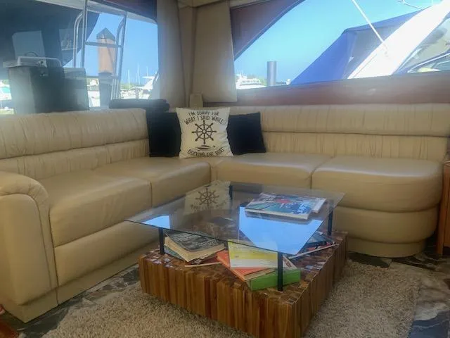  Yacht Photos Pics Luxurious interior of 2002 Viking 55 Convertible yacht with beige leather seating and glass table.