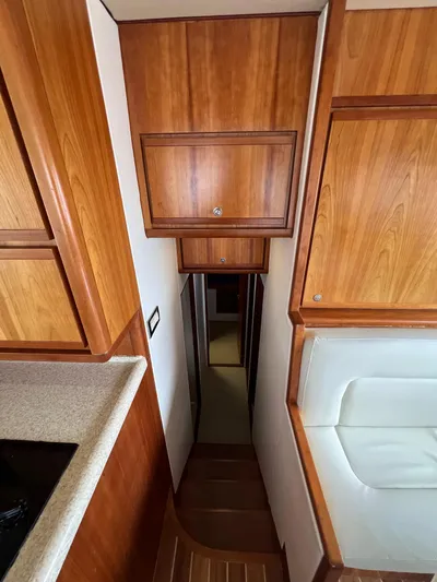 No Name Yacht Photos Pics Interior of 2009 Bertram 45 Convertible yacht with wooden cabinetry and narrow hallway.
