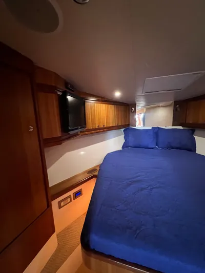 No Name Yacht Photos Pics Interior of 2009 Bertram 45 Convertible yacht with cozy bed and wooden cabinetry.