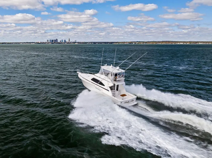 Bella Vita Yacht Photos Pics 2010 Bertram Convertible yacht cruising on open water under a partly cloudy sky.