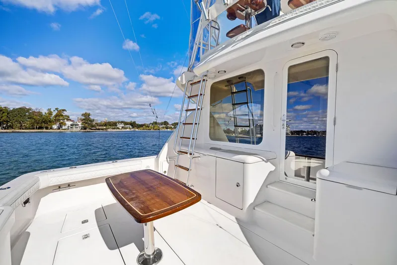 Bella Vita Yacht Photos Pics 2010 Bertram Convertible yacht deck with table, ladder, and ocean view.