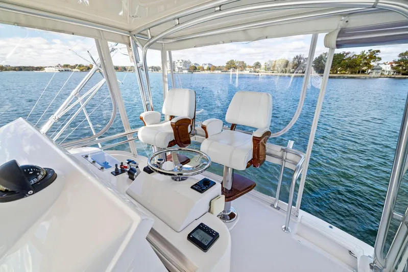 Bella Vita Yacht Photos Pics Interior of 2010 Bertram Convertible yacht with helm and seating, overlooking serene water.