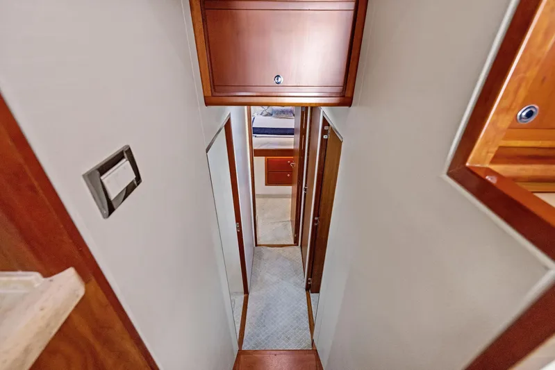 Bella Vita Yacht Photos Pics Interior hallway of 2010 Bertram Convertible yacht with wooden cabinetry.