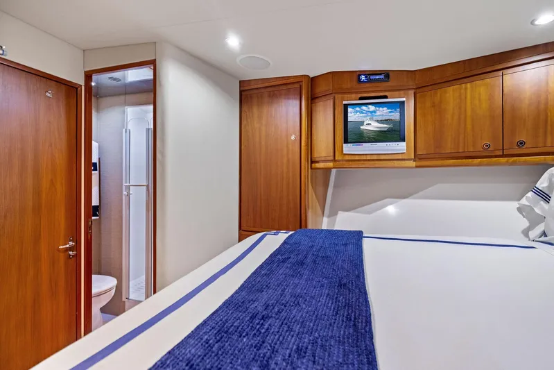 Bella Vita Yacht Photos Pics Interior of 2010 Bertram Convertible yacht with wood cabinetry and cozy bedroom.