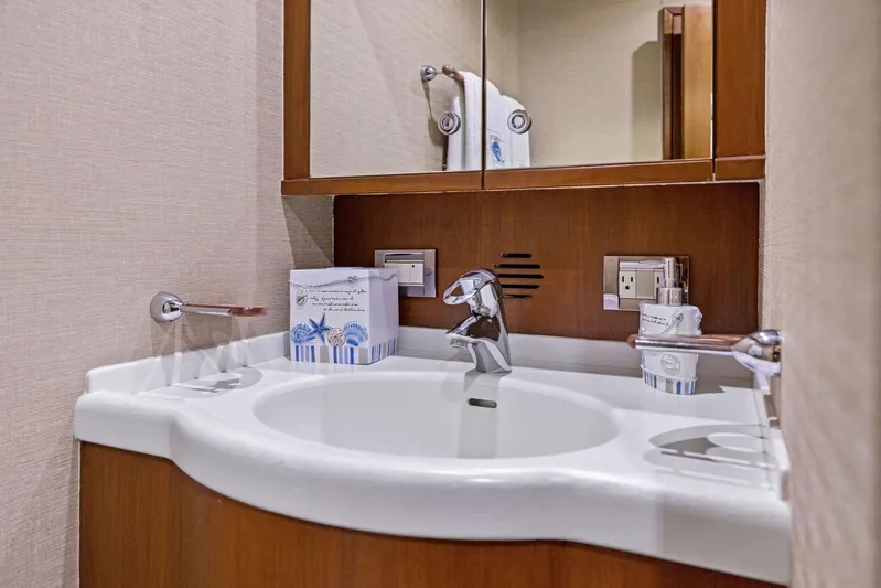 Bella Vita Yacht Photos Pics Luxurious bathroom in 2010 Bertram Convertible yacht with modern fixtures and wooden cabinetry.