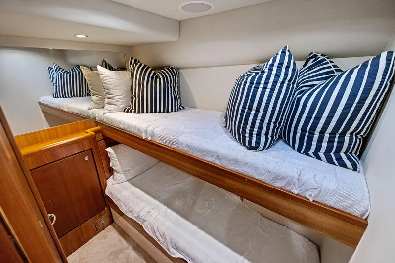 Bella Vita Yacht Photos Pics 2010 Bertram Convertible yacht interior with cozy bunk beds and striped pillows.