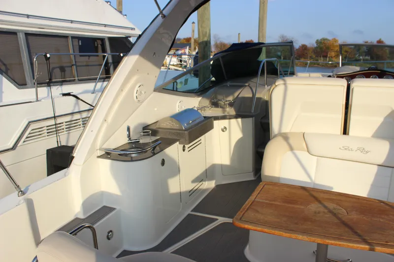  Yacht Photos Pics 2012 Sea Ray 330 Sundancer interior with seating, sink, and grill in a marina setting.