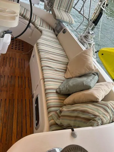 Walkabout Yacht Photos Pics 1997 Beneteau Oceanis 461 sailboat interior with striped cushions and wooden flooring.