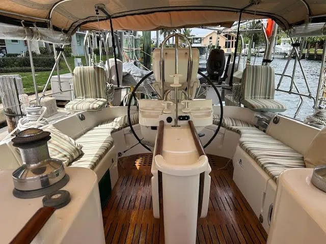 Walkabout Yacht Photos Pics 1997 Beneteau Oceanis 461 yacht cockpit with striped cushions and wooden flooring.