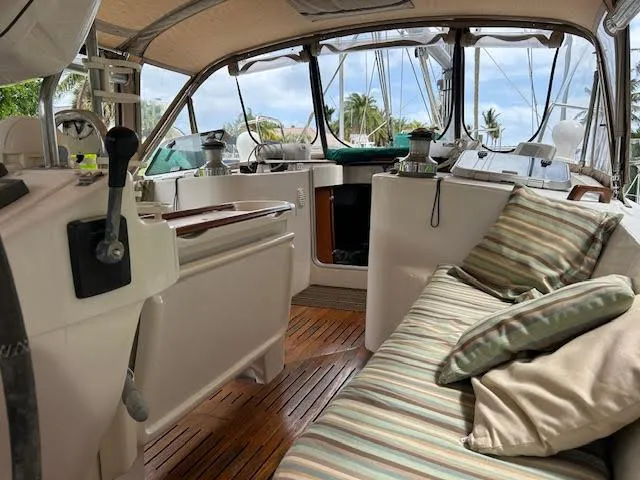 Walkabout Yacht Photos Pics 1997 Beneteau Oceanis 461 yacht cockpit with striped cushions and wooden flooring.