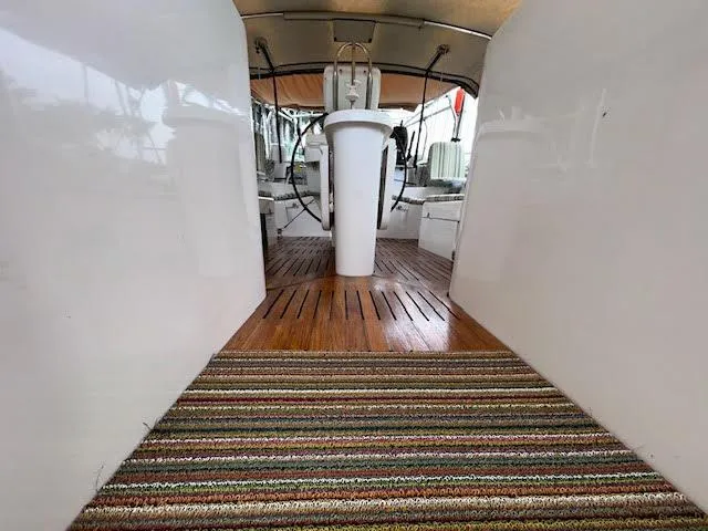 Walkabout Yacht Photos Pics Interior view of 1997 Beneteau Oceanis 461 sailboat with wooden flooring and striped rug.