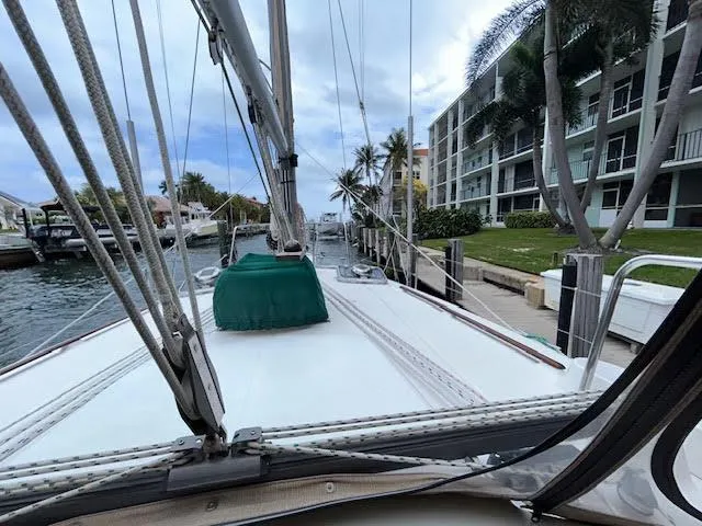 Walkabout Yacht Photos Pics 1997 Beneteau Oceanis 461 sailboat docked near waterfront buildings and palm trees.