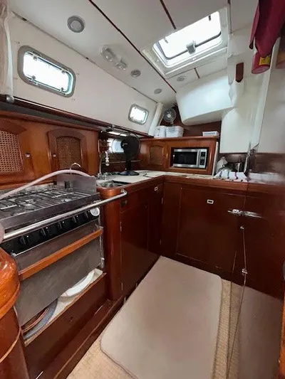 Walkabout Yacht Photos Pics Interior of 1997 Beneteau Oceanis 461 yacht kitchen with wood cabinetry and appliances.