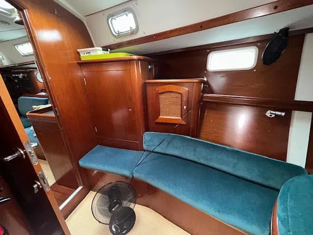 Walkabout Yacht Photos Pics Interior of 1997 Beneteau Oceanis 461 sailboat with wooden cabinetry and blue seating.