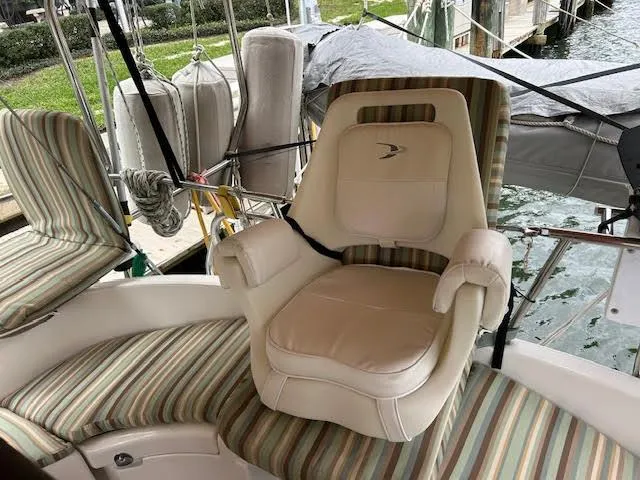 Walkabout Yacht Photos Pics Captain's chair on 1997 Beneteau Oceanis 461 sailboat, featuring striped upholstery and dockside view.