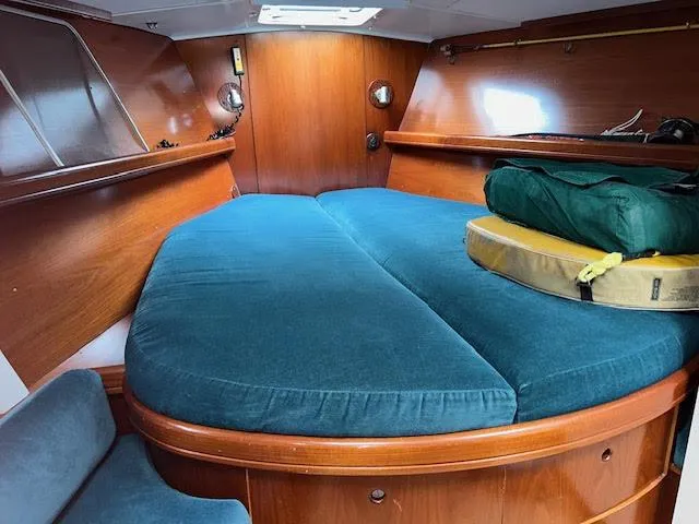 Walkabout Yacht Photos Pics Interior cabin of 1997 Beneteau Oceanis 461 sailboat with blue cushions and wooden finish.