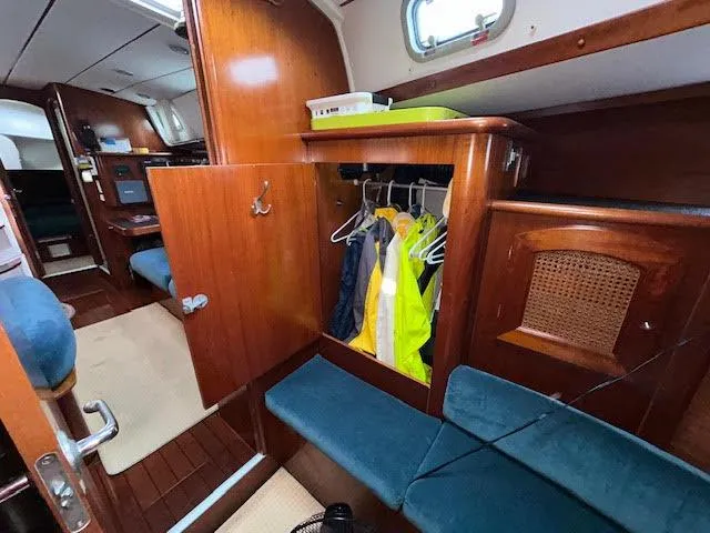 Walkabout Yacht Photos Pics Interior of 1997 Beneteau Oceanis 461 sailboat with wooden cabinetry and hanging jackets.