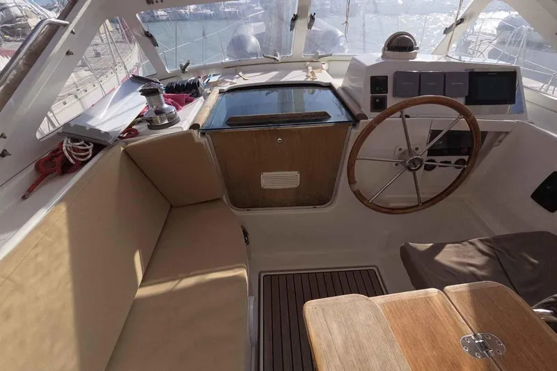 My Way Yacht Photos Pics Cockpit of 2004 Beneteau Oceanis 42CC sailboat with wooden steering wheel and seating.