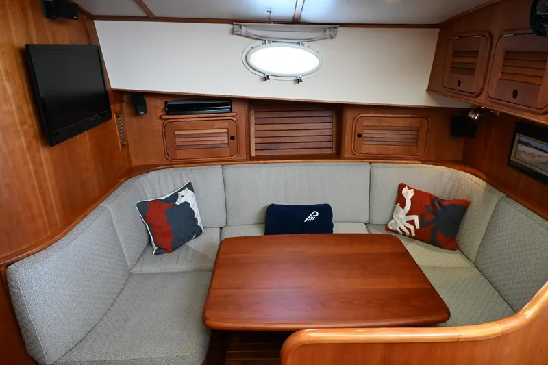 Carol Anne Yacht Photos Pics Cozy interior of 2007 Hinckley Talaria 44 MY yacht with cushioned seating and wooden table.