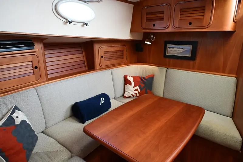 Carol Anne Yacht Photos Pics Cozy interior of 2007 Hinckley Talaria 44 MY with wooden table and cushioned seating.