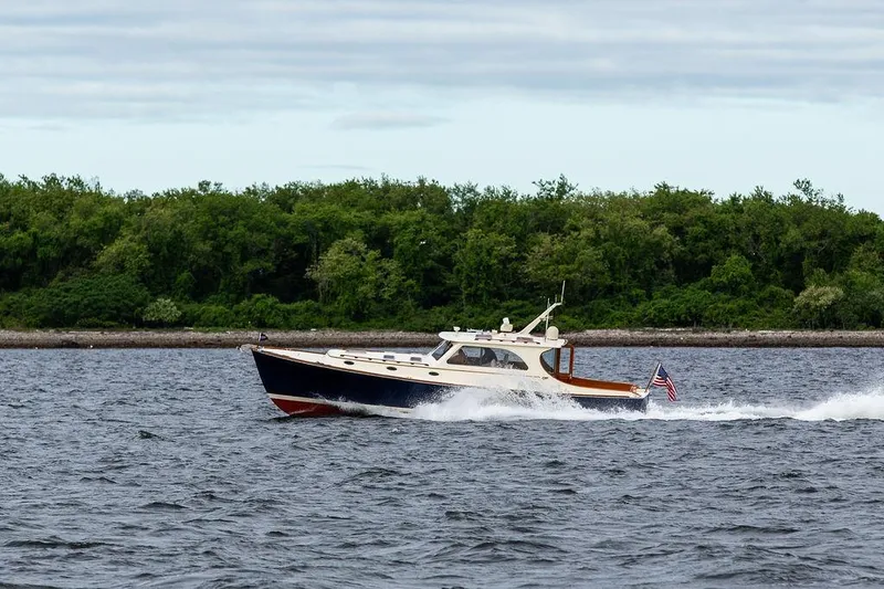 Carol Anne Yacht Photos Pics 2007 Hinckley Talaria 44 MY cruising on water with lush green shoreline in background.