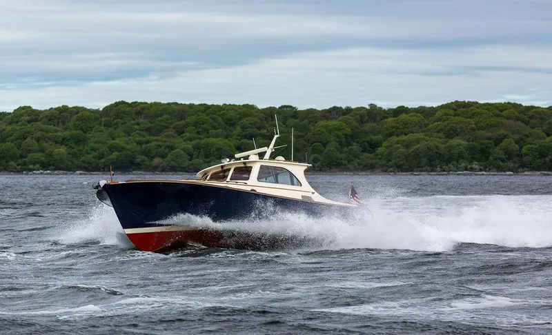 Carol Anne Yacht Photos Pics 2007 Hinckley Talaria 44 MY cruising on water with lush green shoreline in background.