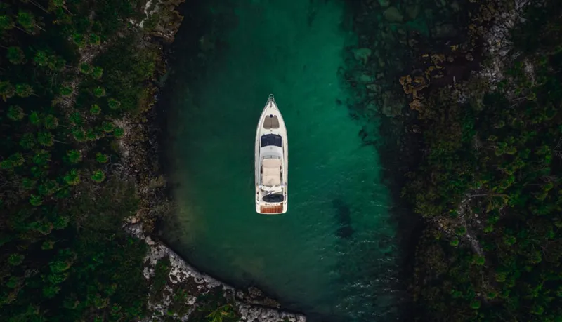 Belle Yacht Photos Pics Aerial view of 2004 Azimut 55E yacht in a serene, green water cove.