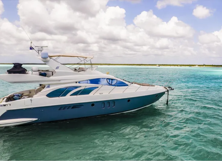 Belle Yacht Photos Pics 2004 Azimut 55E yacht cruising on turquoise waters under a cloudy sky.