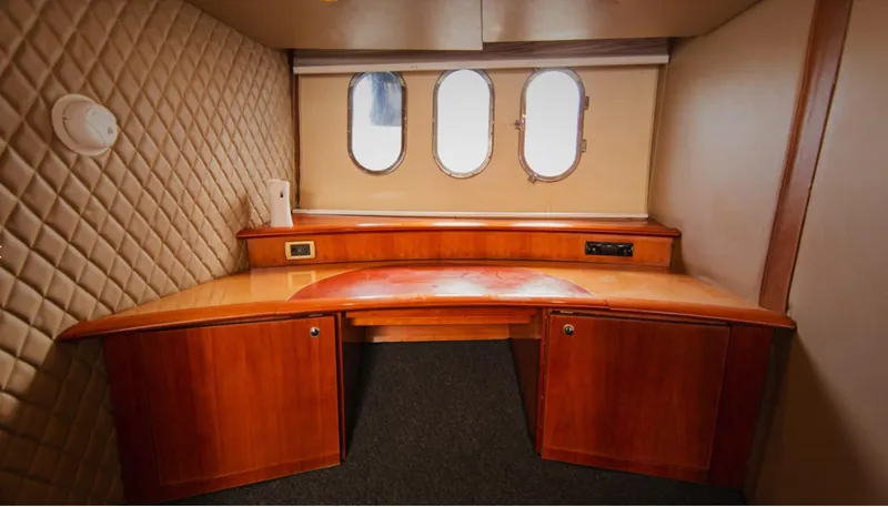 Belle Yacht Photos Pics Interior cabin of 2004 Azimut 55E yacht with wooden desk and porthole windows.
