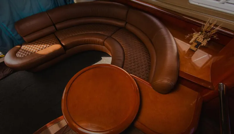 Belle Yacht Photos Pics Luxurious leather seating in 2004 Azimut 55E yacht interior with elegant wooden table.