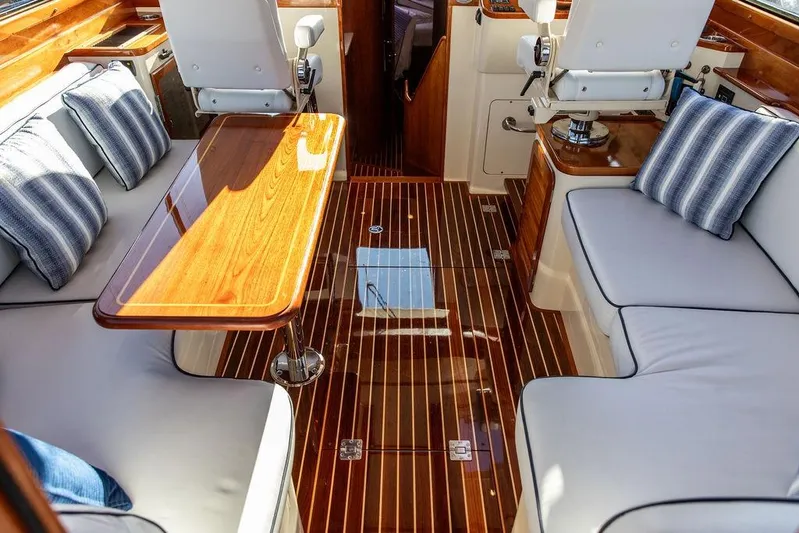 Mon Amour Yacht Photos Pics Luxurious interior of 2005 Hinckley Talaria 44 yacht with elegant wood finishes and plush seating.