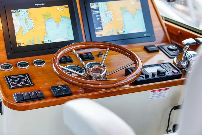 Mon Amour Yacht Photos Pics Helm of 2005 Hinckley Talaria 44 with navigation screens and wooden steering wheel.