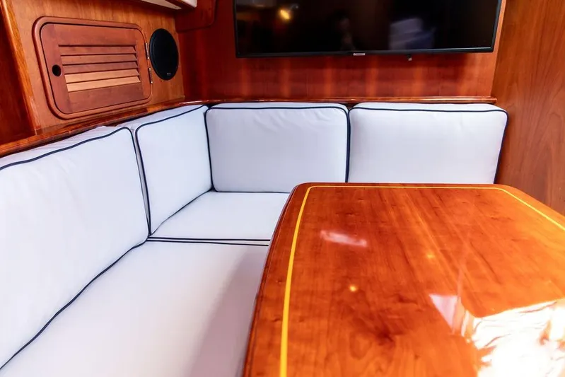 Mon Amour Yacht Photos Pics Luxurious interior of 2005 Hinckley Talaria 44 yacht with elegant wood finish and cushioned seating.