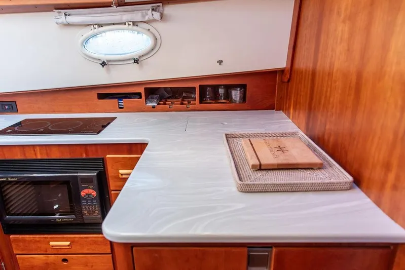 Mon Amour Yacht Photos Pics 2005 Hinckley Talaria 44 yacht kitchen with stove, microwave, and wooden cabinetry.