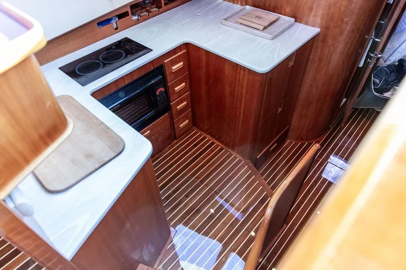 Mon Amour Yacht Photos Pics Luxurious 2005 Hinckley Talaria 44 yacht interior with modern kitchen and wooden flooring.