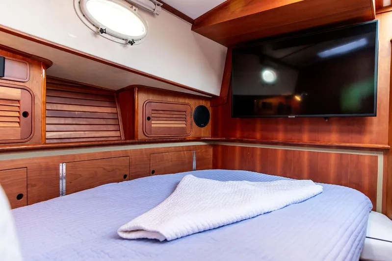 Mon Amour Yacht Photos Pics Luxurious 2005 Hinckley Talaria 44 yacht cabin with wood paneling and a large TV.