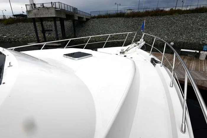  Yacht Photos Pics 2001 Symbol Raised Pilothouse Motoryacht docked, showcasing sleek white deck and railing.