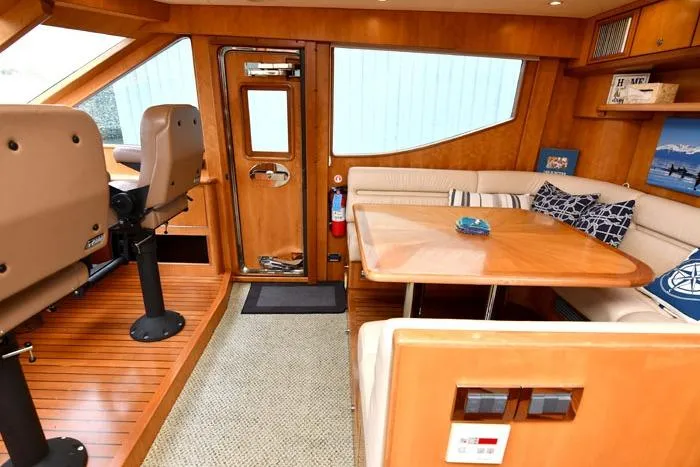  Yacht Photos Pics Luxurious 2001 Symbol Raised Pilothouse Motoryacht interior with seating and wooden accents.