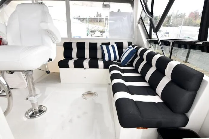  Yacht Photos Pics Luxurious 2001 Symbol Raised Pilothouse Motoryacht interior with striped seating and captain's chair.