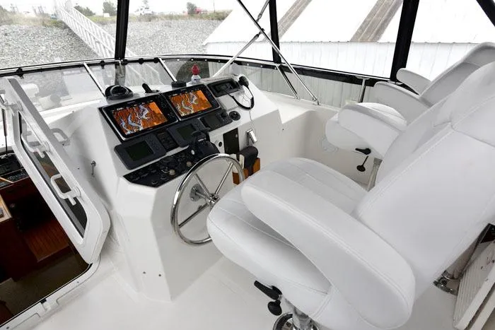  Yacht Photos Pics Pilothouse of 2001 Symbol Raised Pilothouse Motoryacht with navigation screens and white seating.