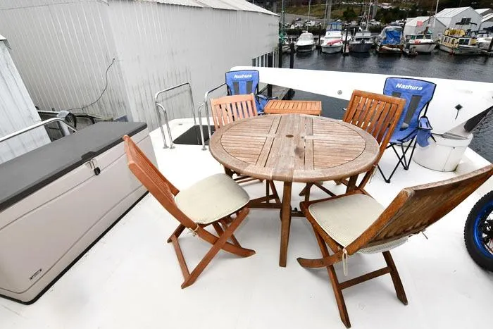  Yacht Photos Pics Outdoor seating on 2001 Symbol Raised Pilothouse Motoryacht with wooden table and chairs.
